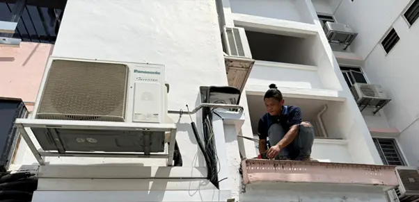 Aircon servicing Singapore technician fixing outdoor unit Aircon servicing Singapore technician fixing outdoor unit