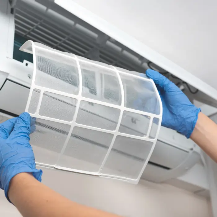 Hands holding an air conditioner filter