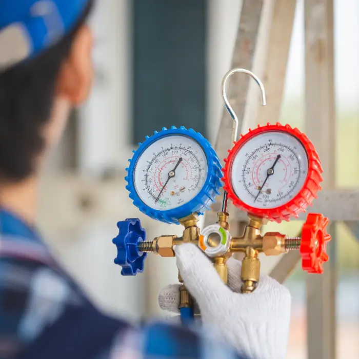 Technician holding AC manifold gauge