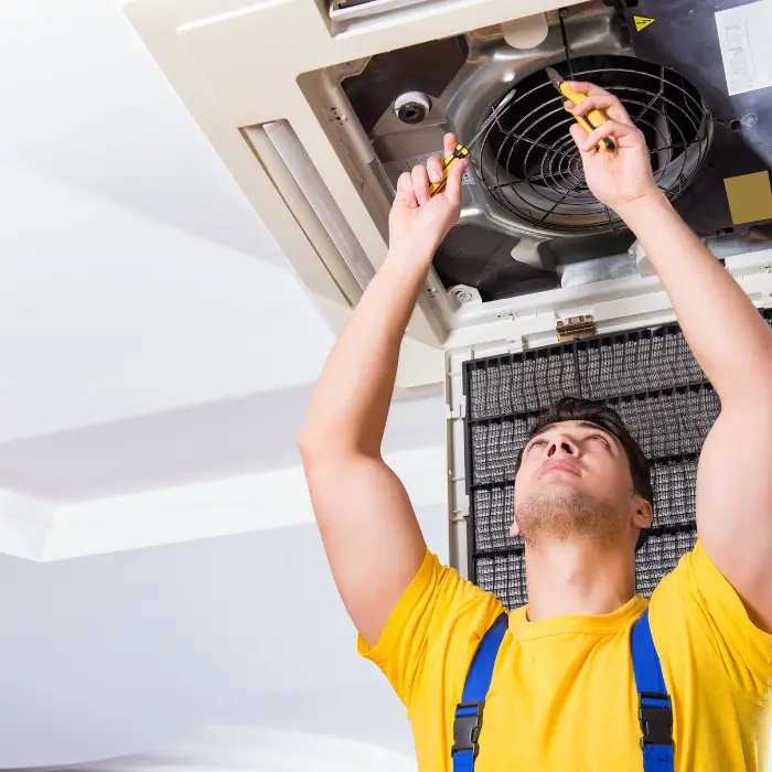 Technician fixing ceiling air conditioner