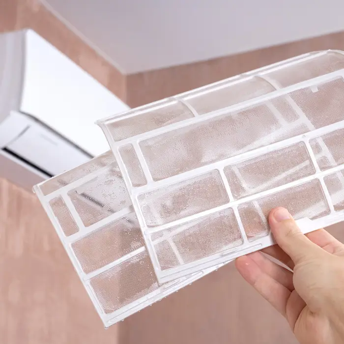 Hand holding dirty air conditioner filters