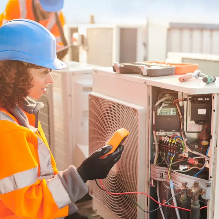 Technician testing outdoor AC unit