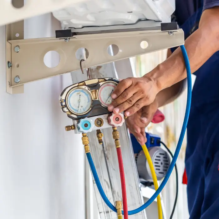 Technician checking air conditioning pressure gauges