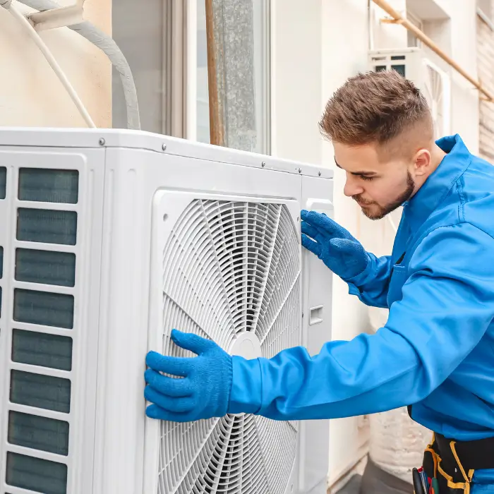 Technician inspecting outdoor air conditioning unit